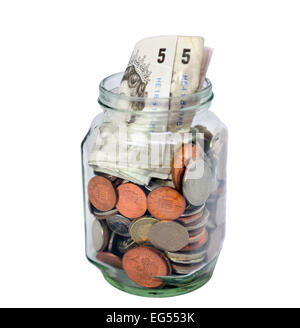 Tagliare fuori il vasetto di vetro pieno di Regno Unito British monete e banconote su sfondo bianco Foto Stock