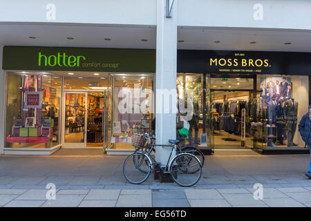 Più caldo e Moss Bros shop fronti in Petty Cury della città di Cambridge Cambridgeshire England Foto Stock