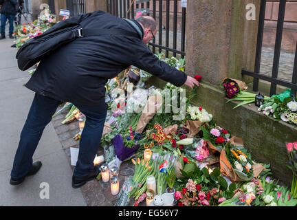 Un uomo la posa di fiori per commemorare per un uomo ucciso a Copenaghen della sinagoga principale durante l'attacco terroristico del 15 febbraio 2015, Danimarca Foto Stock