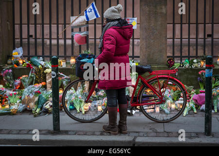 Una donna guarda i fiori a Copenaghen della sinagoga principale dove un uomo è stato ucciso nel corso di un attentato terrorista del 15 febbraio 2015 Foto Stock