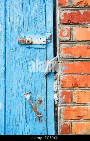 Dipinto di blu vecchia porta di legno con i fermi da vicino Foto Stock