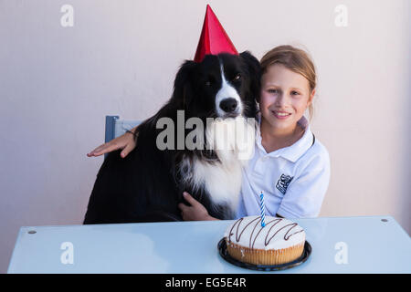 Ollie il Border Collie festeggia il suo primo compleanno con una ragazza giovane membro della sua nuova famiglia home. Foto Stock