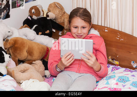 Una giovane ragazza sul suo i pad. Foto Stock