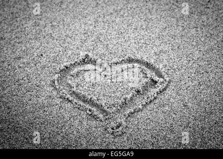 Forma di cuore sulla sabbia. Romantico, bianco e nero, disegnato a mano. Foto Stock