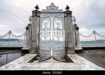Porta del Palazzo Dolmabahce stretto del Bosforo Istanbul Turchia // ISTANBUL, Turchia — porta che si apre sullo stretto del Bosforo presso il Palazzo Dolmabahce. Il Palazzo Dolmabahce, sulle rive dello stretto del Bosforo, fu il centro amministrativo dell'Impero Ottomano dal 1856 al 1887 e dal 1909 al 1922. Costruito e decorato in stile barocco ottomano, si estende lungo una sezione della costa europea dello stretto del Bosforo nel centro di Istanbul. Foto Stock