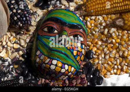 Una maschera colorata decora un tavolo pieno di pannocchie di granoturco in 'Tepetlixpa Banca del seme', creato da Tomas Villanueva Buendia 'Tomaicito' Foto Stock