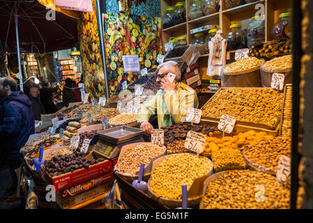 Negozio di noci e cereali del Bazar delle Spezie Istanbul Turchia | ISTANBUL, Turchia — Un negozio che vende noci e cereali al Bazar delle Spezie (Mısır Çarşısı, conosciuto anche come il Bazar Egiziano) nel distretto di Eminönü a Istanbul, vicino al ponte di Galata. Il bazar è uno dei più grandi e antichi mercati coperti della città, costruito nei primi anni '1660 come arasta generatrice di entrate della külliye della Nuova Moschea, dotata da Valide Sultan Turhan Hatice Sultan, con gli affitti dei suoi circa 88 negozi a volta storici permanentemente dedicati alla manutenzione della moschea. Spezie, frutta secca, noci e dolciumi hanno a lungo definito th Foto Stock