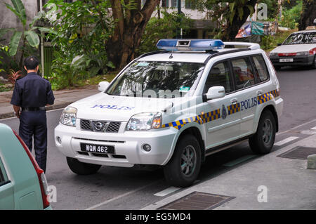 Una polizia malese auto e poliziotto di pattuglia nella città di Sandakan, sulla costa nord-est del Borneo Foto Stock