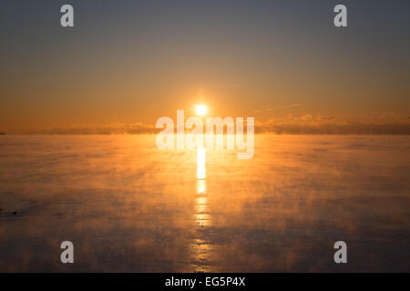 Il sole sorge sopra il vapore acque del lago Ontario come -25C airmass polare inonda il Toronto area & Nord America orientale Foto Stock