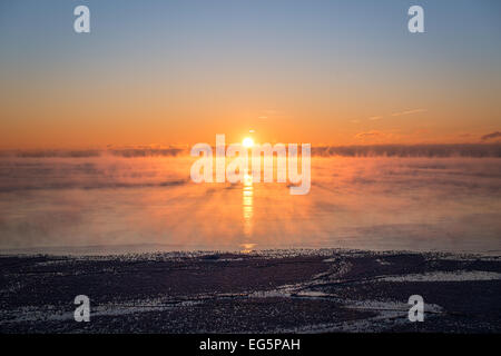 Il sole sorge sopra il vapore acque del lago Ontario come -25C airmass polare inonda il Toronto area & Nord America orientale Foto Stock