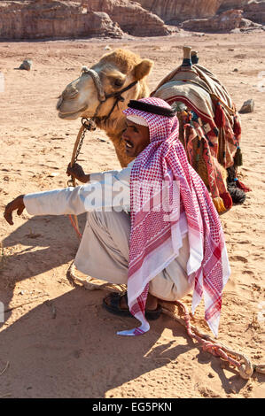 Il cammello e il beduino arabo in attesa per i turisti nel deserto paesaggio Foto Stock