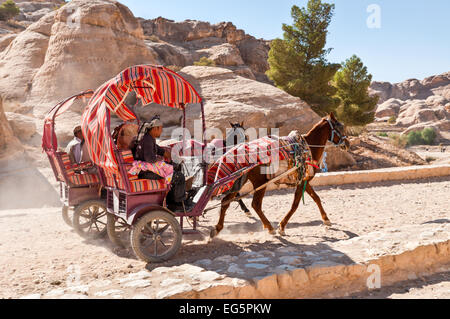 I turisti in sella a un cavallo disegnato carrello in Petra, Giordania. Foto Stock