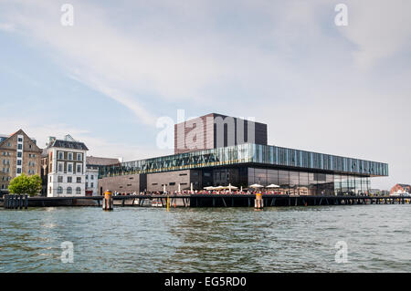 La gente seduta nel cafe a sul lungomare vicino al moderno edificio della Royal Danish Playhouse. Foto Stock