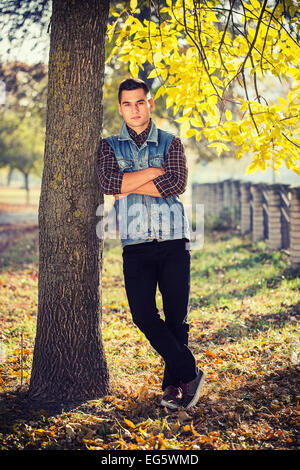 Uomo bello sorge in un parco Foto Stock