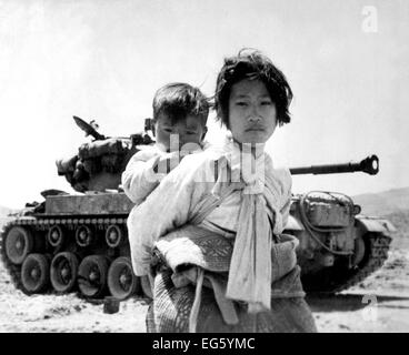 Guerra di Corea (1950-1953) con il suo fratello sulla sua schiena un stanco della guerra coreana stancamente ha ragazza trudges da una fase di stallo M-26 serbatoio, a Haengju, Corea. Giugno 9, 1951. Foto: Il Mag. Versione Riveduta L Spencer, UAF. (Marina) Guerra & CONFLITTO PRENOTA #: 1485 Foto Stock