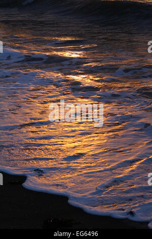 Aberystwyth, Wales, Regno Unito. 17 Febbraio, 2015. Regno Unito meteo. I morenti raggi del sole cadono sul surf al litorale in Aberystwyth, Wales, Regno Unito - John Gilbey 17-Feb-2015 Credito: John Gilbey/Alamy Live News Foto Stock