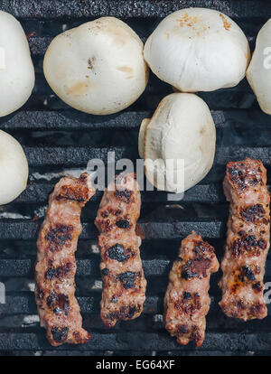 Cevapcici - Carni macinate rotoli e champignon - Bianco di funghi - su un grill Foto Stock