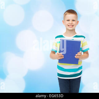 Poco sorridente studente Ragazzo con libro blu Foto Stock