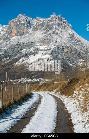 Pista innevata con tracce di pneumatici che conducono verso la coperta di neve montagna, Sinsat, Ariège, Pirenei francesi, Francia Foto Stock