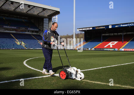 Blackburn Rovers FC Groundsman che segna il campo sotto il cielo azzurro nuvoloso e il sole prima di una partita in casa, Ewood Park, Blackburn, Lancashire, Regno Unito Foto Stock