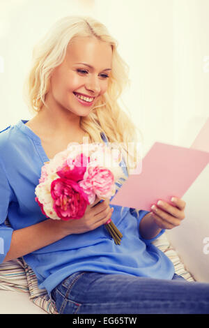 Donna sorridente con la carta e bouquet di fiori Foto Stock