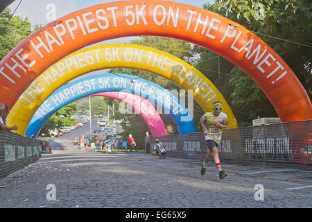 Asheville, North Carolina, Stati Uniti d'America - 26 luglio 2014: un giovane maschio runner coperto di colorante colorato si avvicina al traguardo Foto Stock