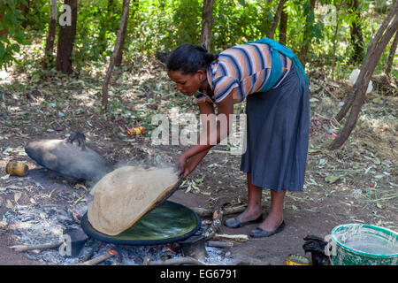 Una giovane donna fare Injera (Etiope pane piatto), Lalibela, Etiopia Foto Stock