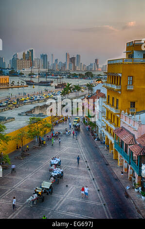 Cartagena, Colombia - Febbraio 21st, 2014 - Horsedrawn carrelli e haukers attendere per turisti e frequentatori del ristorante nella Plaza Foto Stock