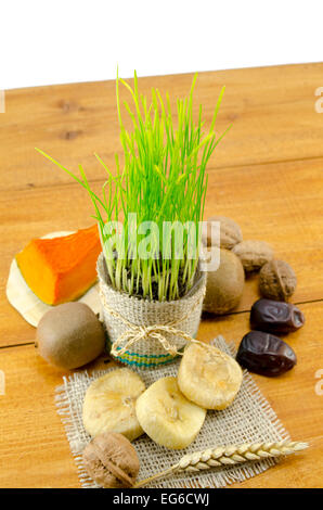 Natale Ortodosso offerte giovani compresi grano verde, secchi e frutta fresca su una tavola di legno, isolato Foto Stock