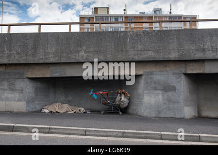 Sleeping senzatetto e carrello sotto il ponte dell'autostrada, Cape Town, Western Cape, Sud Africa Foto Stock