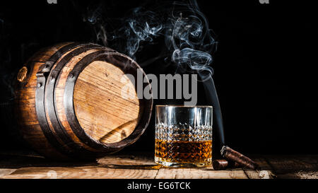 Bicchiere di alcool e il fumo di sigaro nobile su sfondo nero Foto Stock