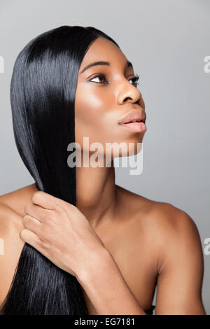 Profilo di un giovane bellezza nera con lunghi rettilinei e capelli luminosi Foto Stock