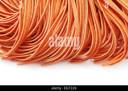 Fettuccine alla pasta di colore rosso su bianco Foto Stock