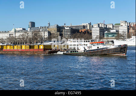 La Cory Riverside tug riguadagnare il traino chiatte a valle sul fiume Tamigi a Londra. Foto Stock