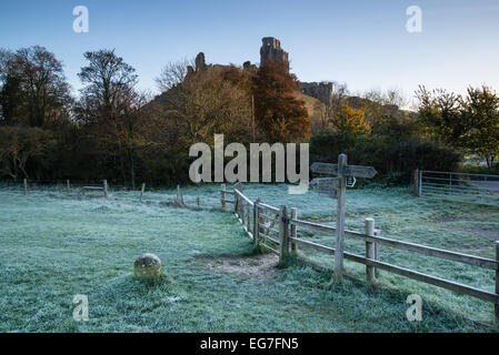 Corfe Castle sunrise nel Dorset su nebbia fredda mattina autunnale. Foto Stock