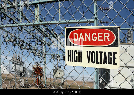 Un valore di tensione alto segnale di avvertimento sul recinto intorno a una sottostazione elettrica. Foto Stock