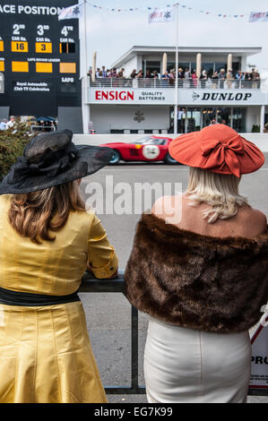 Donne in costume guarda il Goodwood. Femmine guardando vintage motor racing box con area e scheda di giro Foto Stock