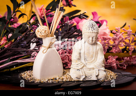 L'incenso e la statua del Buddha con fiori spa concept Foto Stock