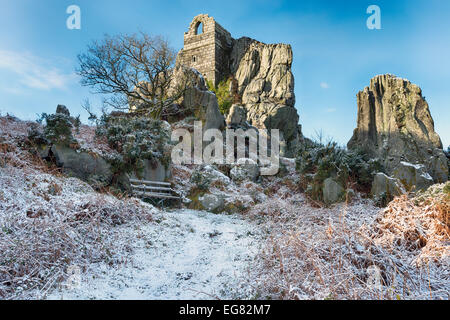 Inverno neve a Roche Rock un affioramento di granito scoscese con un antico rovinato cappella costruita nella roccia sulla brughiera di Roche n Foto Stock