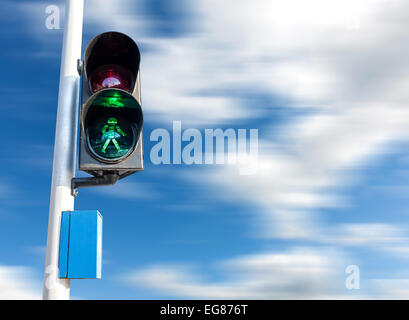 Il colore verde del semaforo per i pedoni, moto cielo sfocata. Foto Stock
