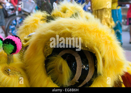 Un drago giallo costume poggia su un marciapiede prima di una performance durante il Nuovo Anno Cinese in Kampong Cham, Cambogia. Foto Stock