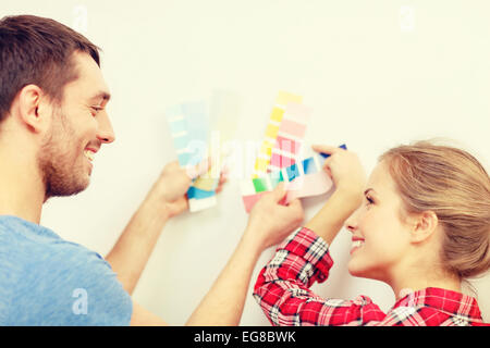 Coppia sorridente guardando i campioni di colore sono a casa Foto Stock