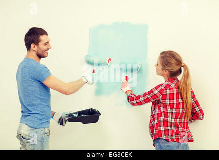 Sorridente giovane pittura parete di casa Foto Stock