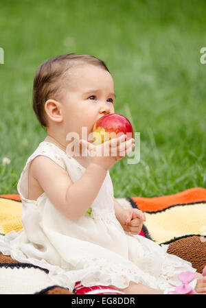 Carino bambina di mangiare una mela rossa Foto Stock