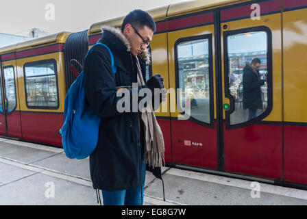 Berlino, Germania, metropolitana tedesca, piattaforma, Underground, Europe, Chinese Tourist guardando iPhone vicino al treno, viaggiatori diversi Foto Stock