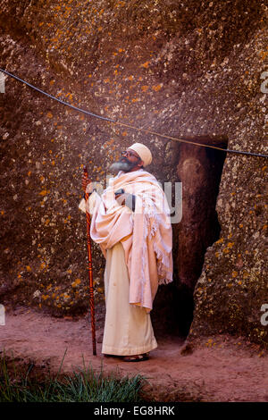 Un sacerdote pregare presso Biete Giyorgis (Saint Georges) Chiesa, Lalibela, Etiopia Foto Stock