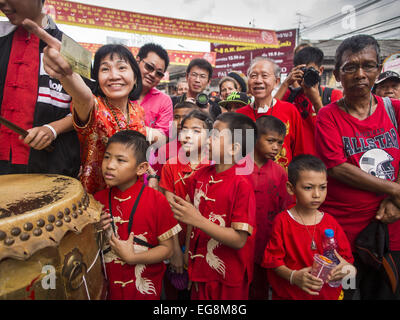 Bangkok, Tailandia. 19 Feb, 2015. Una donna e bambini guardare un lion dance troupe durante il Nuovo Anno Cinese festeggiamenti in Bangkok. Il 2015 è l'anno di ovini in zodiaco cinese. Le pecore è l ottavo segno in astrologia Cinese e '8'' è considerato un numero fortunato. Essa simboleggia la sapienza, fortuna e prosperità. Di etnia cinese costituiscono quasi il 15% della popolazione thailandese. Anno Nuovo Cinese (chiamato anche Tet o capodanno nuovo anno lunare) è ampiamente celebrato in Thailandia, specialmente nelle zone urbane che hanno grandi popolazioni cinesi. Credit: Jack Kurtz/ZUMA filo/Alamy Live News Foto Stock