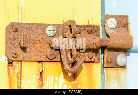 Vecchio arrugginito blocco su una tettoia in legno porta. Foto Stock