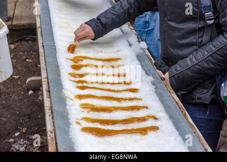 Maple taffy sulla neve durante lo zucchero shack periodo. In Quebec, Canada. Foto Stock