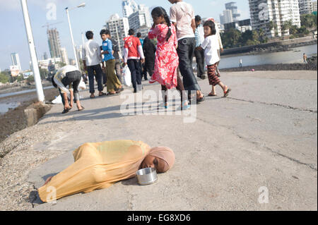 Mendicanti accumulato sulla causeway al Haji Ali moschea e Dargah , Mahalaxmi , Mumbai. Foto Stock